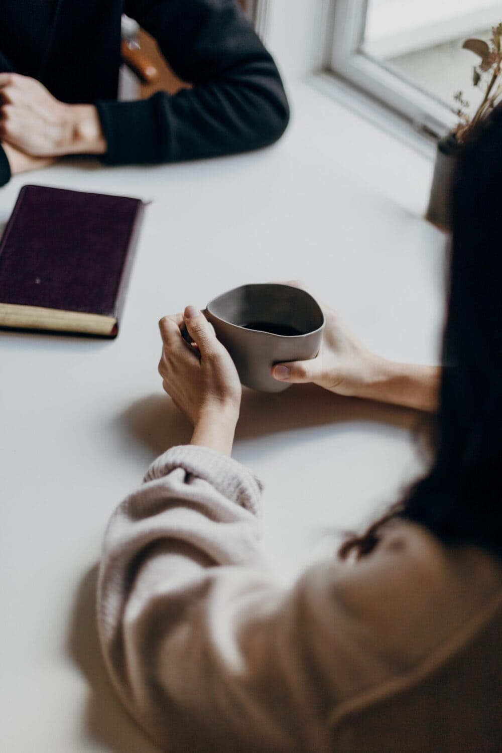 Coffee time for two woman at a table with a book