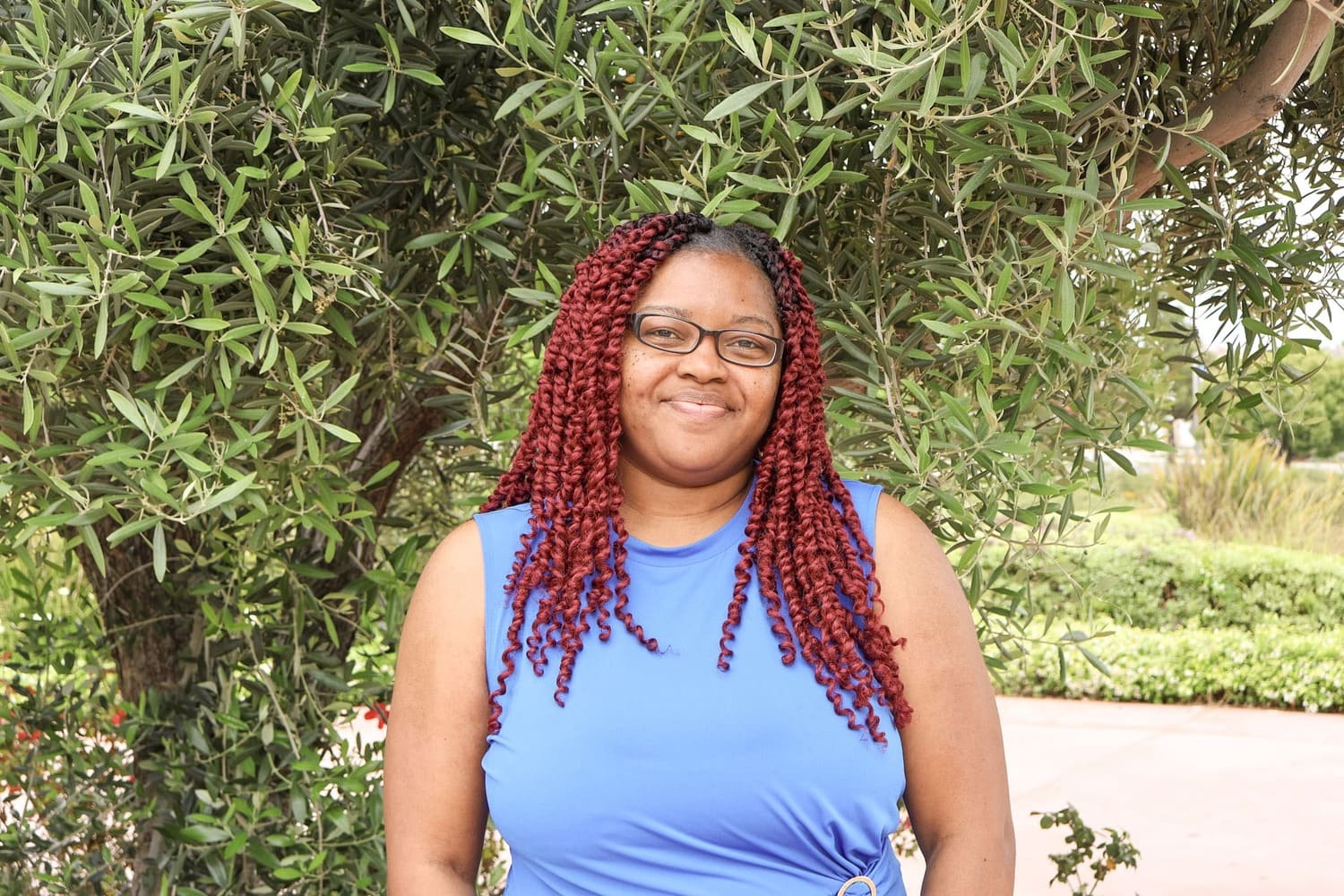 Dr. Carmen Stephens Powerful Woman In Blue Dress Standing By Trees