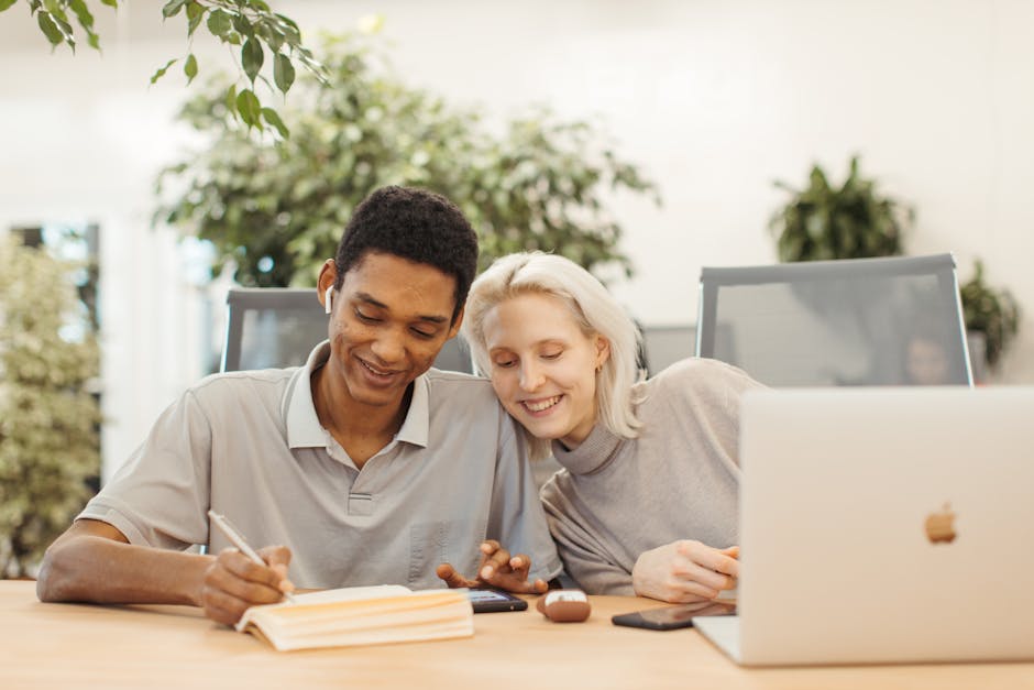 Young diverse colleagues smiling and working together in a bright, modern office setting.